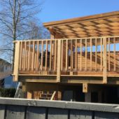 Custom wooden deck with railings and trellis.