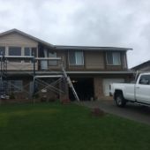 Scaffold along front of Campbell River house. Wood siding being replaced.